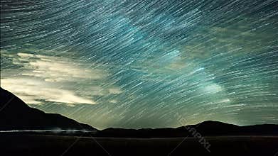 Timelapse night sky stars and Star Trails on mountains background.