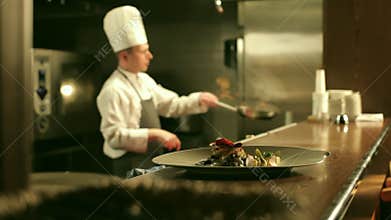 Male Chef is Cooking Flambe in Restaurant Kitchen