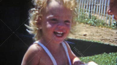 BOULDER, COLORADO 1951: Mom holding baby while big sister kisses her.