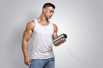 Muscular fitness male holding protein shake bottle