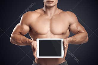 Fitness male holding horizontally digital tablet with blank scre