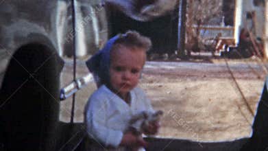 BOULDER, COLORADO 1951: Baby girl helping wash family Ford car.