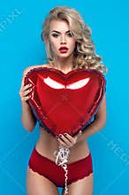 Young blond woman in lingerie with heart balloon