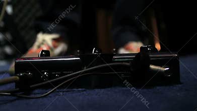 Guitarist presses with his foot on the effects pedal - press once on the pedal