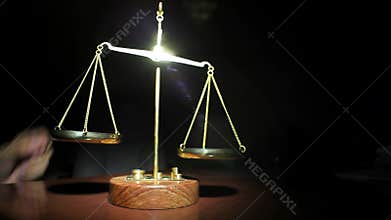Man Placing Weights on Golden Balance Scales