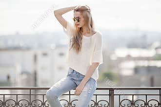 Fashion model. Summer look. Jeans, sweater, sunglasses.