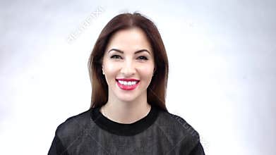 Beautiful young woman showing her smile or white teeth, isolated on white background. Slow motion