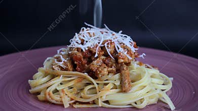 Putting parmesan cheese on spaghetti