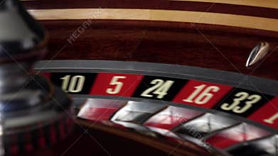 Usual roulette wheel running with white ball, side view