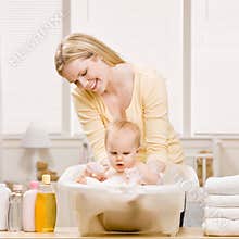 Mother give baby girl a bath