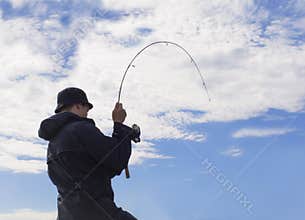 Man fishing pulling hard at rod.