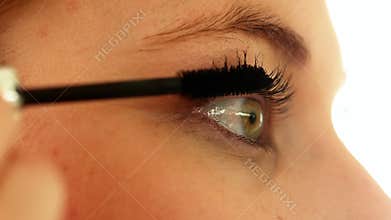 Woman putting on mascara