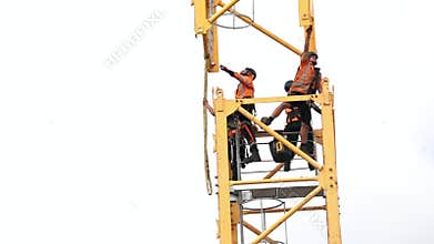 Builders assemble a construction tower crane
