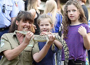 Australian wildlife woman park ranger teaching children about native crocodiles at local fair