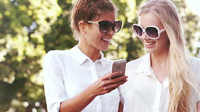 Smiling friends with using smartphone