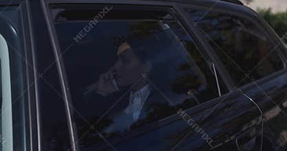 Serious young executive on phone in limousine