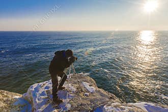 Photographer on the rocks taking landscape pictures