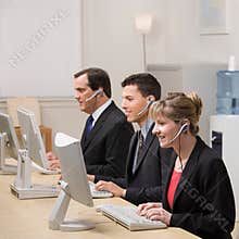 Co-workers working at computers in call center