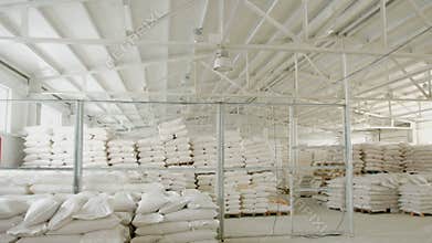 Bags with flour in warehouse of flour factory. Flour stock. Mill warehouse