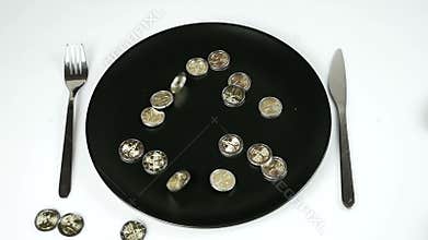 Euro coins falling on a black plate