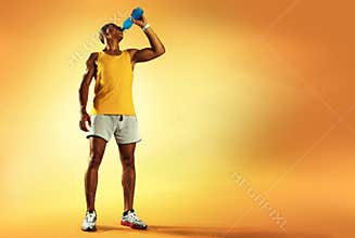 Young muscular build man drinking water of bottle
