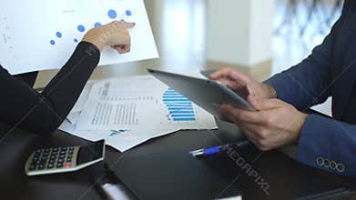Business people discussing the charts and graphs showing the results of their successful teamwork