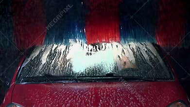 Brush is rolling and cleaning the roof of the car in slow motion