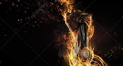 Man's hand holding up trophy medal.