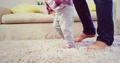 Dad assisting baby to walk