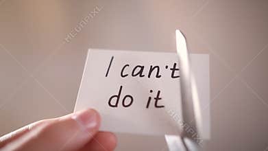 Man using scissors to remove the word can't to read I can do it concept for self belief