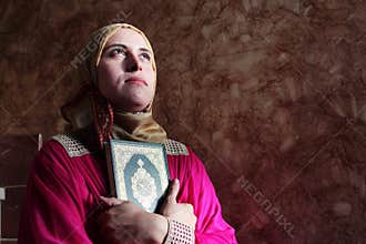 Arab muslim woman with koran holy book wearing hijab