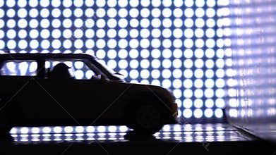 Car with crash-test dummy hitting the wall. Crash test laboratory concept. Purple lights background, super slow motion