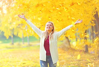 Leaf fall, happy expression young woman having fun in warm sunny autumn