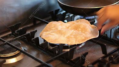 Cooking chapati on a gas ring.