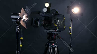 Camcorder, video camera and professional studio lights in a broadcasting studio.