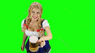 Woman in bavarian costume gives beer and winking eyes. Oktoberfest. Green screen