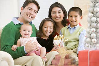 Family With New Born,Sitting On Sofa,Holding Prese