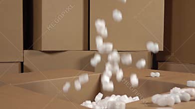 Pouring soft polystyrene pieces into big carton. Shockproof packaging material. Safety, security and insurance concepts