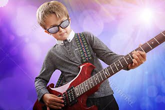 Boy playing electric guitar in talent show on stage