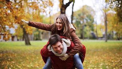 Happy young couple having fun in autumn park