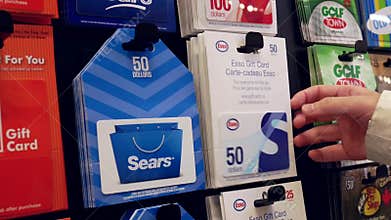 Woman picking fifty dollars Esso gift card