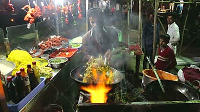 Indian man preparing local food at a street stand in night in Mumbai.