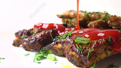 Pouring red tomato sauce over freshly cooked meat. Cooking spare ribs. 4K close-up video