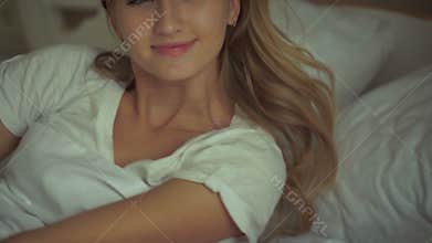 Beautiful lifestyle woman waking up in bed at home