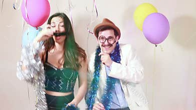 Woman and man having awesome time in photo booth