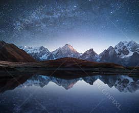 Night landscape with a mountain lake and a starry sky