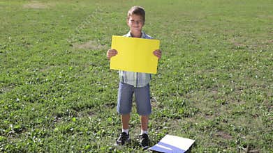 Smiling boy standing with empty blank banner