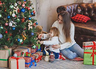 Happy mother and child decorating a Christmas tree