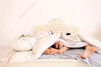 Close-up family feet that lie and sleep on bed