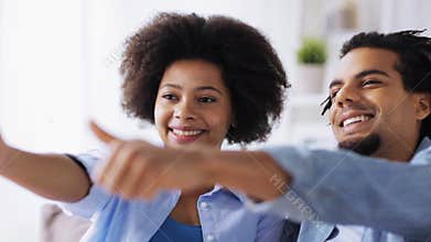 Happy couple showing thumbs up at home